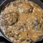 Hamburger steak smothered in brown gravy with mushrooms and onions Recipe Image