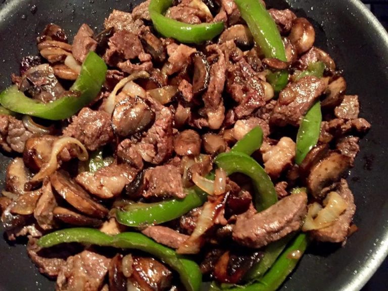 Grilled steak fajitas with bell peppers and red onion